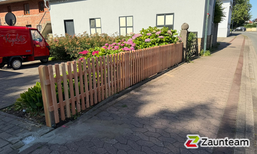 Staketen Holz vor die Pfosten / Lärchenkantpfosten braun eingerammt wurde in Bückeburg von Zaunteam Schaumburger Land, Stadthagen im Jahr 2026 erstellt.