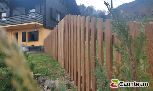 Staketen Holz vor die Pfosten / Lärchenkantpfosten braun eingerammt wurde in Vérossaz von Zaunteam Wallis, Niedergesteln im Jahr 2023 erstellt.