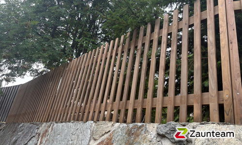 Staketen Holz vor die Pfosten / Lärchenkantpfosten braun eingerammt wurde in Bürchen von Zaunteam Wallis, Niedergesteln im Jahr 2026 erstellt.