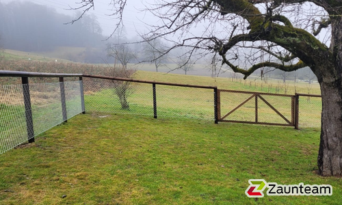 Halbrundlattenzaun mit Diagonalgeflecht verzinkt mit Lärchenkantpfosten braun wurde in Scherz von Zaunteam Aargau, Egliswil im Jahr 2025 erstellt.