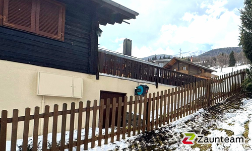 Staketen Holz vor die Pfosten / Lärchenkantpfosten braun eingerammt wurde in Unterbäch von Zaunteam Wallis, Niedergesteln im Jahr 2026 erstellt.