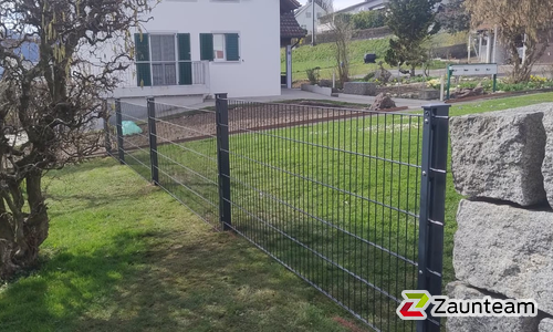 Doppelstabmatten leicht vorverzinkt und anthrazit beschichtet mit Pfosten 60 x 40 mit Abdeckleisten einbetoniert wurde in Würenlos von Zaunteam Aargau, Egliswil im Jahr 2026 erstellt.