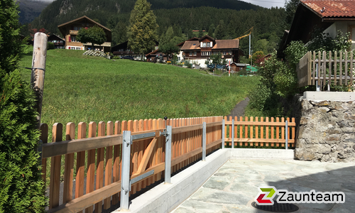 Lärchenzaun gerade mit T-Stahlpfosten verzinkt einbetoniert wurde in Grindelwald von Zaunteam Berner Oberland, Ringgenberg im Jahr 2017 erstellt.
