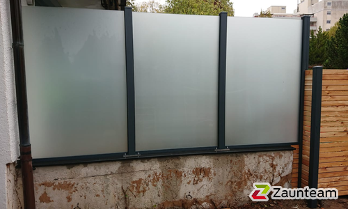 Glas Sichtschutz mit vierkant Aluminium-Nutpfosten mit Fussplatte wurde in Bad Liebenzell von Zaunteam Pforzheim, Neuhausen im Jahr 2023 erstellt.