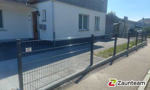 Doppelstabmatten leicht feuerverzinkt und anthrazit beschichtet mit Pfosten 60 x 40 mit Abdeckleisten einbetoniert wurde in Sumiswald von Zaunteam Mittelland, Bützberg im Jahr 2026 erstellt.