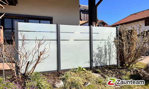 Glas Sichtschutz mit vierkant Aluminium-Nutpfosten einbetoniert wurde in Oberstaufen von Zaunteam Allgäu, Bad Hindelang - Unterjoch im Jahr 2026 erstellt.